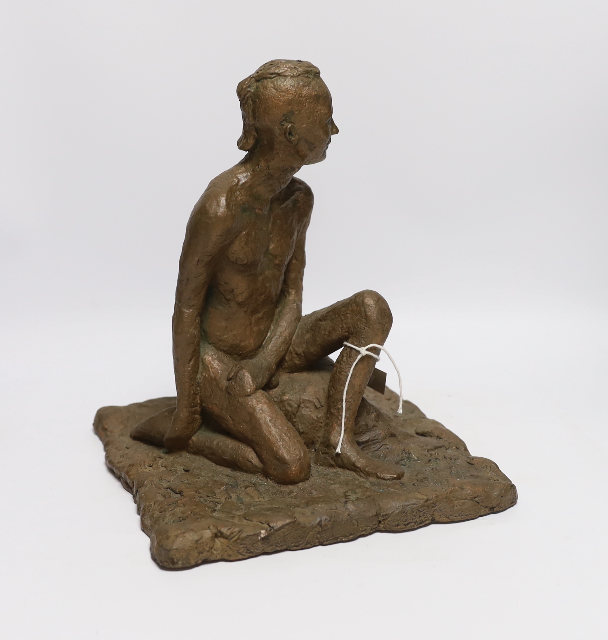 An abstract bronzed resin sculpture of a kneeling man, 30cm